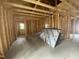 Unfinished living room with exposed beams, bare concrete floor, and a single window provides an opportunity for customization at 233 Jenkins St, Erwin, NC 28334