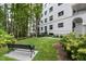 Lush backyard featuring a wrought iron bench, manicured lawn, and mature trees in a serene setting at 620 Wade Ave # 301, Raleigh, NC 27605