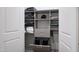 Custom closet with shelving, drawers, two laundry baskets, and hanging rods providing organized storage solutions at 620 Wade Ave # 301, Raleigh, NC 27605