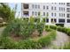 Apartment building with a white brick facade, black windows, and a beautifully landscaped garden with flowering bushes at 620 Wade Ave # 301, Raleigh, NC 27605