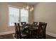 Dining room showcasing a dark wooden table and chairs, paired with a modern chandelier and abundant natural light at 836 Bankston Woods Way, Raleigh, NC 27609
