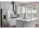 This modern kitchen is upgraded with a gray backsplash and modern stainless steel appliances, and an island at 836 Bankston Woods Way, Raleigh, NC 27609