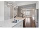 This kitchen offers a stainless steel dishwasher and a sink, with modern light fixtures and an open concept to the living room at 836 Bankston Woods Way, Raleigh, NC 27609