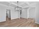 Dining room features coffered ceilings, hardwood floors, and stylish lighting, with open access to other rooms at 2820 Lacy Holt Rd, Graham, NC 27253