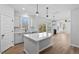 Spacious open-concept kitchen with island flows into living area, featuring abundant natural light and wood floors at 2820 Lacy Holt Rd, Graham, NC 27253