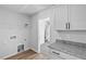 Functional laundry area with granite countertop, washer and dryer hookups and shelving for storage at 2820 Lacy Holt Rd, Graham, NC 27253