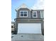 Two-story townhome featuring attached two-car garage with white garage door and gray siding at 1341 Bessie Ct, Wake Forest, NC 27587