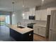 Modern kitchen with stainless appliances, subway tile backsplash, island and white cabinets at 1343 Bessie Ct, Wake Forest, NC 27587