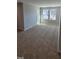 Sunlit living room with plush carpeting, large windows, and neutral paint, creating a welcoming atmosphere at 1349 Bessie Ct, Wake Forest, NC 27587
