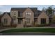 Striking two-story brick home featuring a manicured lawn, refined landscaping, and a welcoming front entrance at 4905 Foxridge Dr, Raleigh, NC 27614