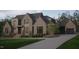 Elegant two-story brick home with a circular driveway, mature landscaping, and a three-car garage at 4905 Foxridge Dr, Raleigh, NC 27614