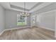 Elegant dining area illuminated by a stylish chandelier, with views of the well-kept outdoors at 119 Water Ave, Wake Forest, NC 27587