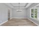 Spacious dining area featuring a modern chandelier, tray ceiling, and ample natural light at 119 Water Ave, Wake Forest, NC 27587