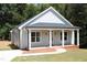 Charming one-story house featuring a covered front porch, freshly painted siding, and manicured lawn at 119 Water Ave, Wake Forest, NC 27587