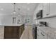 Modern kitchen with stainless steel appliances, granite countertops, and island overlooking living area at 119 Water Ave, Wake Forest, NC 27587
