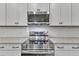 Modern kitchen boasts stainless steel appliances, granite countertops, and white cabinets at 119 Water Ave, Wake Forest, NC 27587