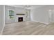 A well-lit living room featuring a fireplace, wood-look flooring, and recessed lighting at 119 Water Ave, Wake Forest, NC 27587
