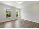 Light-filled bedroom with wood-look flooring, fresh paint, windows, and a ceiling fan at 484 Traditions Grande Blvd # 29, Wake Forest, NC 27587
