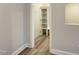 Hallway with luxury vinyl plank flooring leading to a door with built-in shelving for efficient storage at 484 Traditions Grande Blvd # 29, Wake Forest, NC 27587