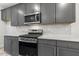 Well-equipped kitchen features gray cabinets, stainless steel appliances, and elegant white countertops and backsplash at 484 Traditions Grande Blvd # 29, Wake Forest, NC 27587
