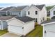 View of the home's rear exterior and detached garage, showcasing the backyard and patio at 9237 Kitchin Farms Way # 429, Wake Forest, NC 27587