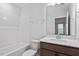 Modern bathroom with bathtub, wood vanity, mirror, and sink with quartz countertops at 9237 Kitchin Farms Way # 429, Wake Forest, NC 27587