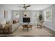 Bright living room features a ceiling fan, fireplace with a white brick surround, and large windows at 1601 Little Falls Dr, Rocky Mount, NC 27801