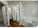 Bathroom featuring wood-look flooring, a soaking tub, and a glass door shower with tile surround at 207 Earnest Way # 15, Kenly, NC 27542