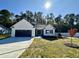 Beautiful single-story home with a well-maintained lawn, a black garage door, and mature trees at 207 Earnest Way # 15, Kenly, NC 27542