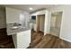 Galley-style kitchen featuring granite countertops, stainless appliances, white cabinets, and wood floors at 207 Earnest Way # 15, Kenly, NC 27542