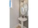 Pedestal sink in half bathroom with round mirror and black faucet at 2401 E Main St, Durham, NC 27703