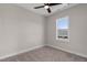 An empty bedroom with a ceiling fan, carpeted floors, and a window providing natural light at 2401 E Main St, Durham, NC 27703