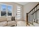 Inviting living room with bright windows, white sofa, and front door to stairs at 2401 E Main St, Durham, NC 27703