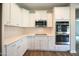Modern kitchen with white cabinets, stainless steel appliances, and white backsplash at 138 Abingdon Farms Dr, Selma, NC 27576
