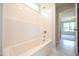 Clean white bathtub and shower in a bright, modern bathroom with tile floors at 236 Abingdon Farms Dr, Selma, NC 27576