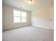Bedroom with neutral walls, carpet, a window letting in natural light, and a door at 236 Abingdon Farms Dr, Selma, NC 27576