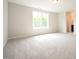 Bright bedroom with plush carpeting and natural light from a large window at 236 Abingdon Farms Dr, Selma, NC 27576