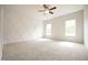 Empty bedroom with a ceiling fan and two bright windows at 236 Abingdon Farms Dr, Selma, NC 27576