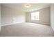 Empty bedroom featuring plush carpeting, neutral tones, a window, and a utility access door at 236 Abingdon Farms Dr, Selma, NC 27576