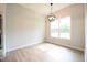 Bright dining area with wood floors, modern chandelier, and natural light from a large window at 236 Abingdon Farms Dr, Selma, NC 27576