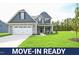 Move-in ready two-story home with gray siding, stone accents, and a two-car garage at 236 Abingdon Farms Dr, Selma, NC 27576