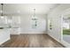 Open dining area with hardwood floors, chandelier, and view to kitchen at 733 Portland Rose Dr, Knightdale, NC 27545