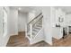 Spacious foyer area with hardwood flooring, staircase, and view into a modern kitchen at 733 Portland Rose Dr, Knightdale, NC 27545