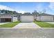 View of garages with paved driveway and green grass with a view of surrounding homes at 733 Portland Rose Dr, Knightdale, NC 27545