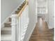 Hallway with stairs and hardwood flooring, leading into a kitchen at 737 Portland Rose Dr, Knightdale, NC 27545
