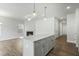 Bright kitchen with island, stylish pendant lights, flowing to the living area with fireplace at 737 Portland Rose Dr, Knightdale, NC 27545