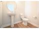 Charming powder room with a pedestal sink, round mirror, and wood-look floors at 76 Abingdon Farms Dr, Selma, NC 27576