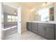 The stylish bathroom features a dual vanity with gray cabinets and tile floors at 76 Abingdon Farms Dr, Selma, NC 27576