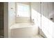 Bright bathroom features a soaking tub beneath a window with natural light at 76 Abingdon Farms Dr, Selma, NC 27576