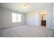 Bedroom view showcases neutral walls, carpet, and an open door leading to the bathroom at 76 Abingdon Farms Dr, Selma, NC 27576